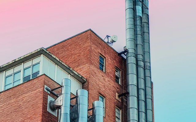 metal chimney pipes on red brick building