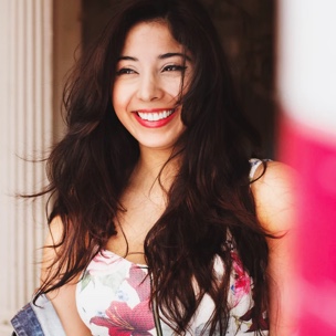 headshot of a smiling person with long wavy hair