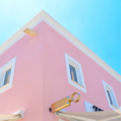 pink building with white windows and blue sky