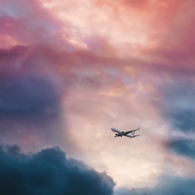 an airplane flying through purple and blue couldy sky